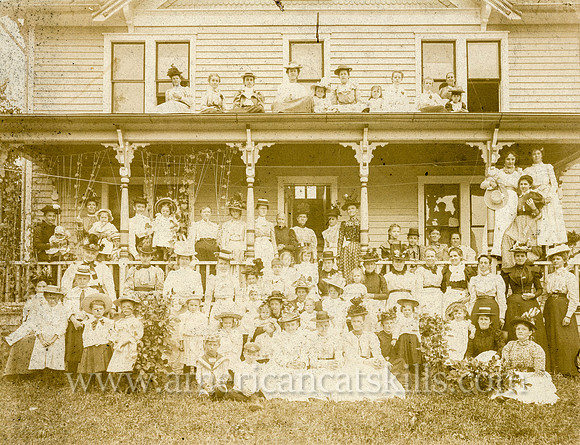 Photograph of a large group of women in front of a house taken by photographer Fred J. Betts of Walton, New York.