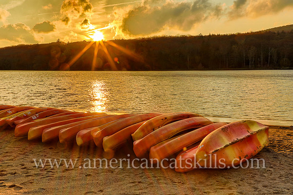 Photograph of kayaks and a sunset at North-South Lake in Haines Falls, New York.