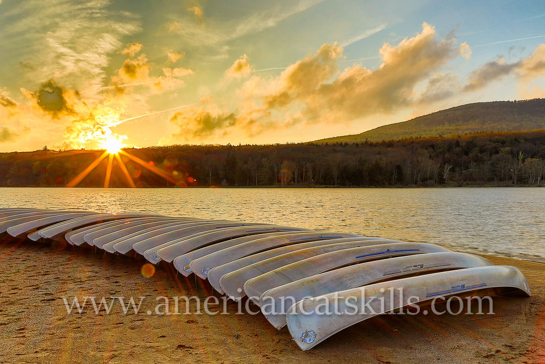 Photograph of canoes and a sunset at North-South Lake in Haines Falls, New York.