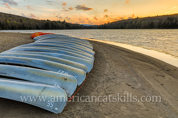Photograph of a line of canoes late in the afternoon at North-South Lake in Haines Falls, New York.