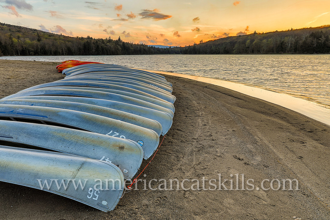 Photograph of a line of canoes late in the afternoon at North-South Lake in Haines Falls, New York.