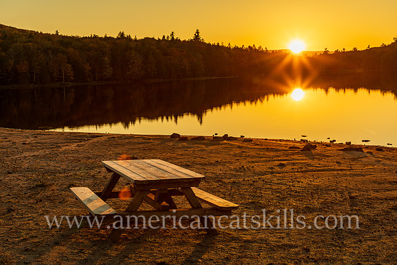 Photograph of a picnic table and a sunset at North-South Lake in Haines Falls, New York.