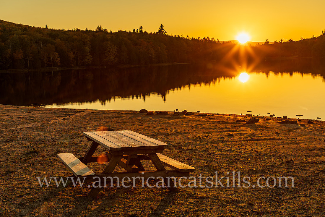 Photograph of a picnic table and a sunset at North-South Lake in Haines Falls, New York.