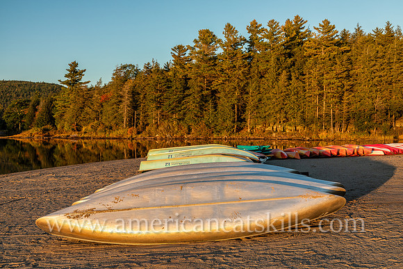 Photograph of canoes lined up on the beach at North-South Lake at Haines Falls, New York.