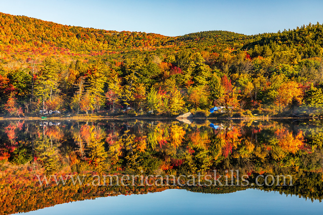 Photograph of a campsite with autumn mountain colors reflecting in the latke at North-South Lake in the Catskills.