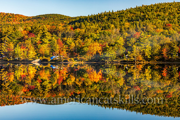 Photograph of the mountain reflecting in the lake with some campers at the lakeside at North-South Lake in the Catskills.