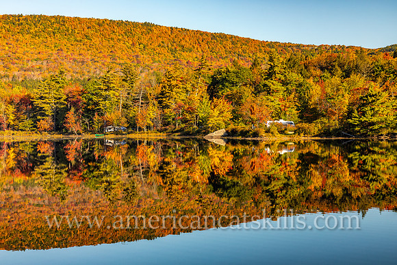 Photograph of an RV on the lakeside with the mountain reflecting in the lake at North-South Lake in the Catskills.