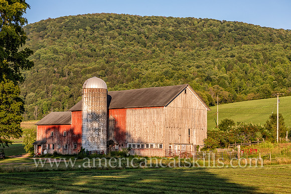 Photograph of a barn with a mountain in the background in Delaware County, New York.
