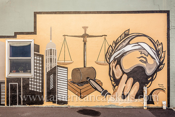 The midtown Kingston mural known as Justice, appropriately located on the side wall of a legal practice, depicts Lady Justice, the scales of justice and a city skyline.