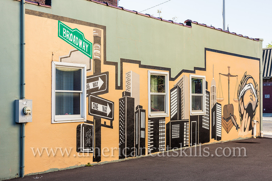 The midtown Kingston mural known as Justice, appropriately located on the side wall of a legal practice, depicts Lady Justice, the scales of justice and a city skyline.