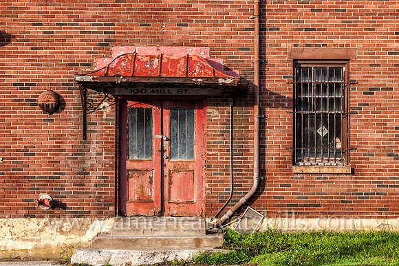 Door and wall on an abandoned red brick building at 100 Mill Street in Liberty, Sullivan County, New York.