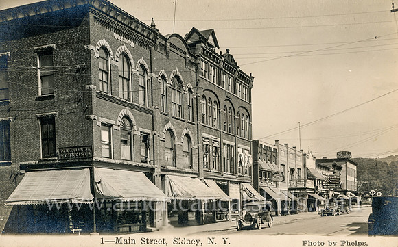 Vintage postcard titled "1_Main Street, Sidney, N. Y." by photographer Charles H. Phelps.