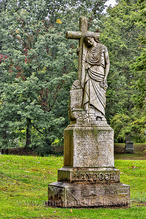 Sculpture of a woman carrying a cross at the Montrepose Cemetery in Kingston, New York.