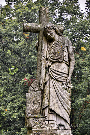 Sculpture of a woman carrying a cross at the Montrepose Cemetery in Kingston, New York.