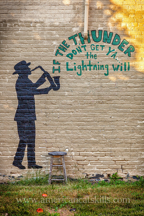 Mural in Kingston, New York with man playing the saxophone with the words “If the thunder don’t get you, the lightning will.”