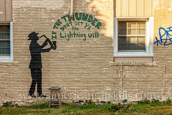 Mural in Kingston, New York with man playing the saxophone with the words “If the thunder don’t get you, the lightning will.”