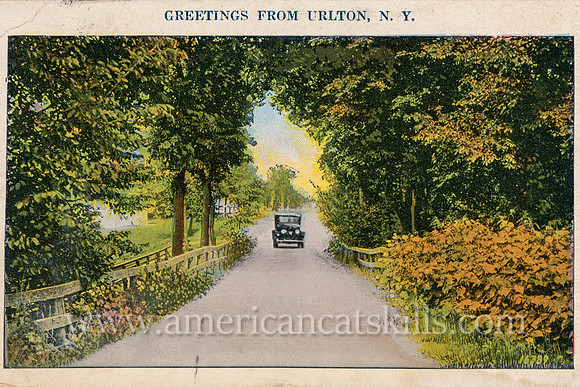 This vintage postcard titled “Greetings from Urlton, N.Y.” depicts a lone car making its way down a pretty countryside lane.