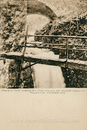 This vintage Catskills postcard depicts the historic stone arch bridge that marks the entrance to the Hell Hole at Platte Clove.