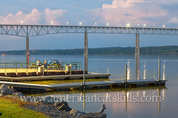 A group of friends hang out on a late summer night at Charles Rider Park along the Hudson River under the Kingston-Rhinecliff bridge.