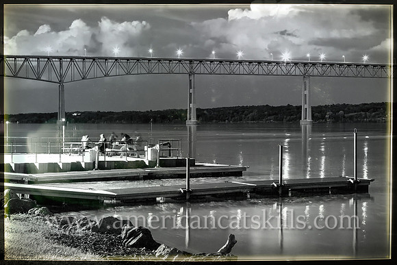 A group of friends hang out on a late summer night at Charles Rider Park along the Hudson River under the Kingston-Rhinecliff bridge.