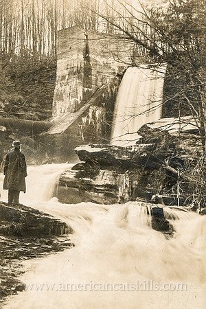 Vintage, untitled postcard by photographer Otto Hillig showing a man standing in front of a free-flowing waterfall.