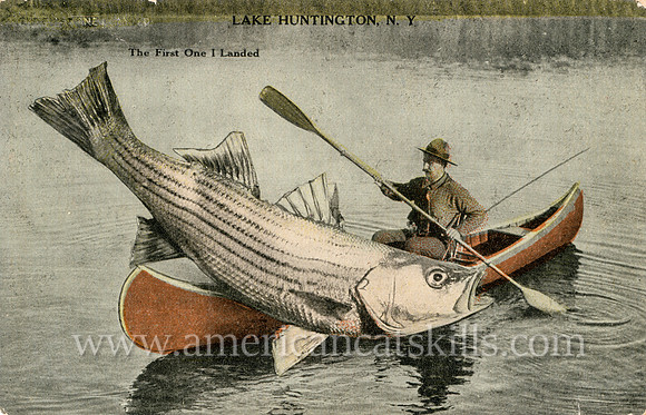Vintage postcard titled "The First One I Landed, Lake Huntington, N. Y." showing a large, fake fish in a canoe with a fisherman.