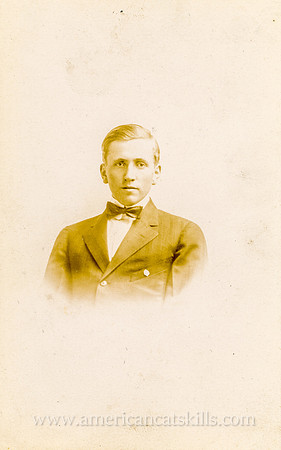 Portrait of a young man in a suit by photographer Howard Wood of Hurleyville, New York.